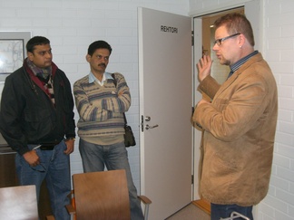 Lukion rehtori Riku Saksholm kertomassa intialaisen GSE-ryhmän johtaja Ramesh Vangalalle ja Samuel Phathipatylle Kalajoen lukion toiminnasta