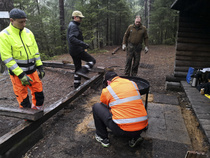 Veli Tomi pulttaa grillin paikoilleen