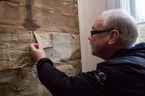 Seinätapetin alta löytyy vanhoja lehtiä, mm Kaiku-lehti. Heidi kertoo, että löytö halutaan jotenkin jättää näkyville ja suojata