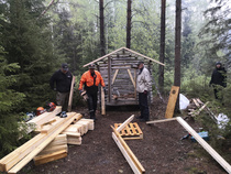 Veljet Pekka, Sauli ja Heikki valmistelevat uutta puuvajan kattoa, Maiju pitää miehille jöötä.